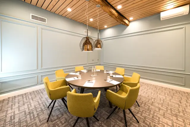 Authentic meeting room in the castle, fixed table, yellow chairs.