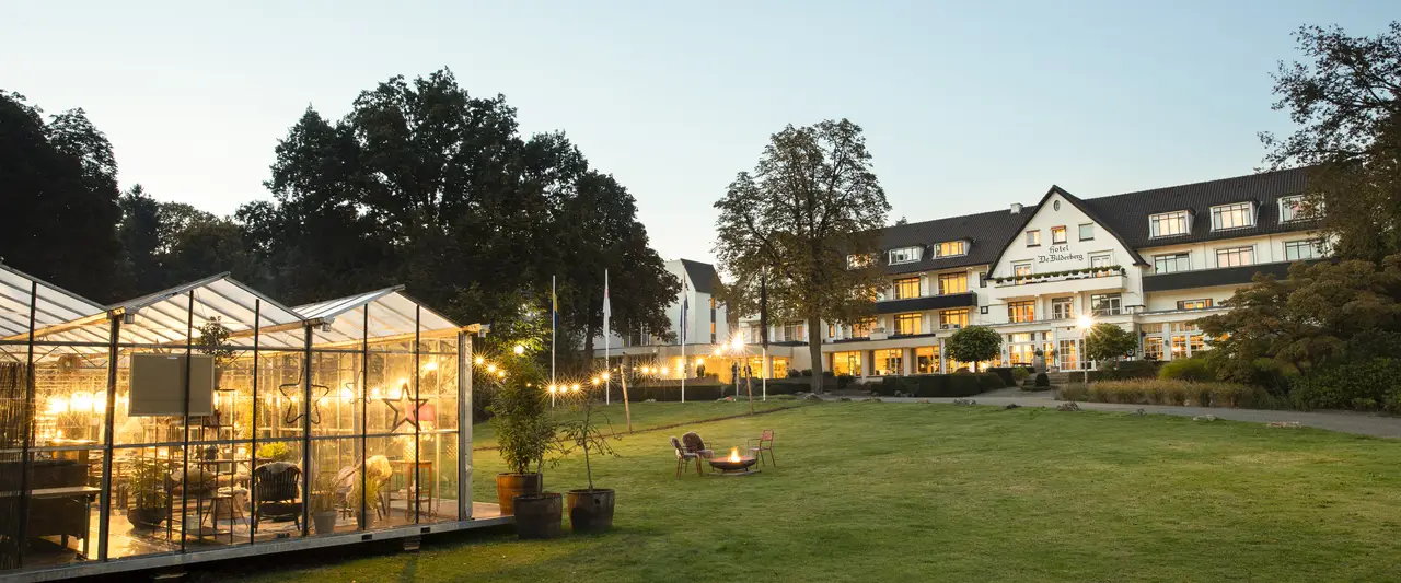 De glazen kas van Winter in the Woods met op de achtergrond Hotel De Bilderberg