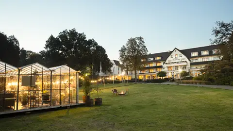 De glazen kas van Winter in the Woods met op de achtergrond Hotel De Bilderberg