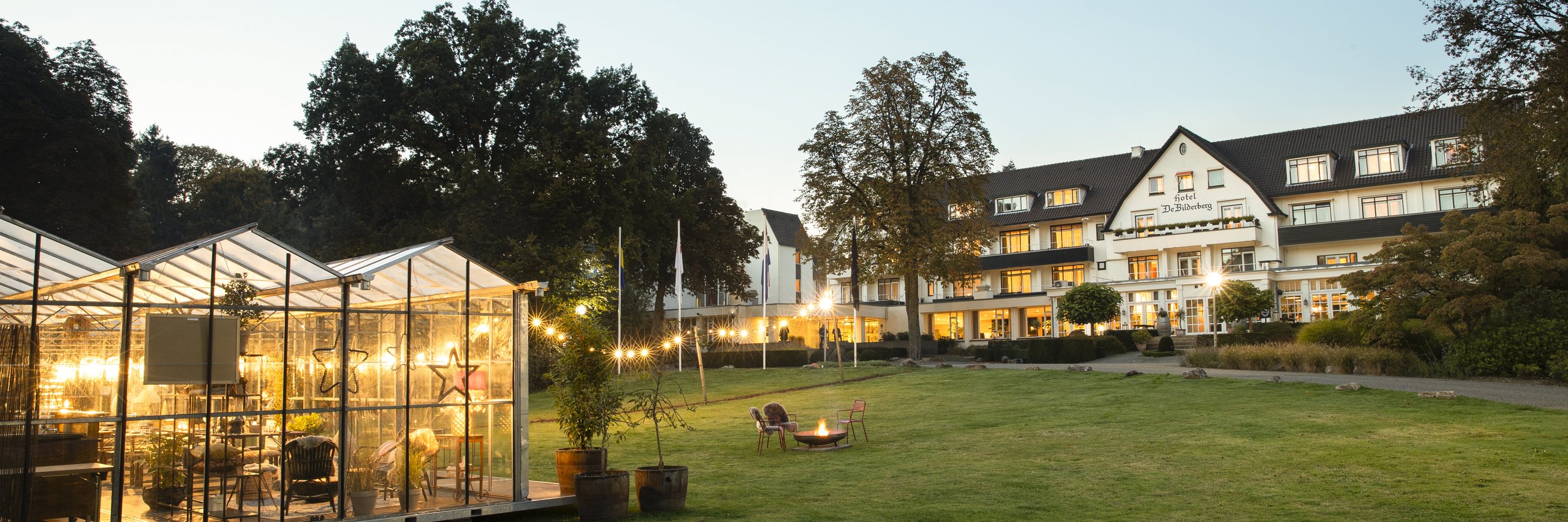 De glazen kas van Winter in the Woods met op de achtergrond Hotel De Bilderberg