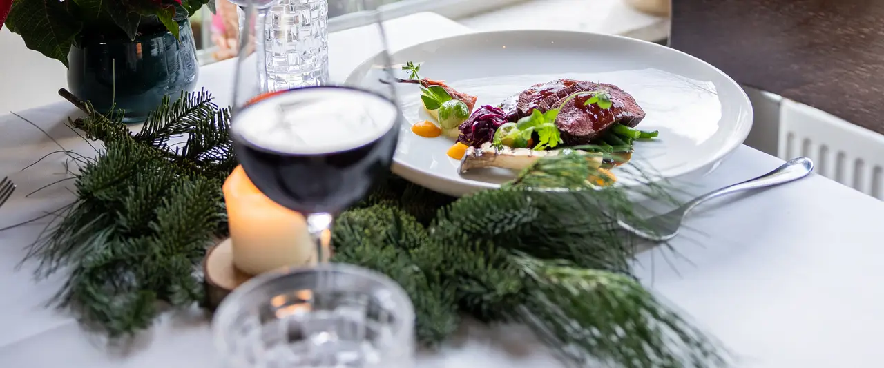 Een kerstgerecht in Restaurant W met een glas rode wijn