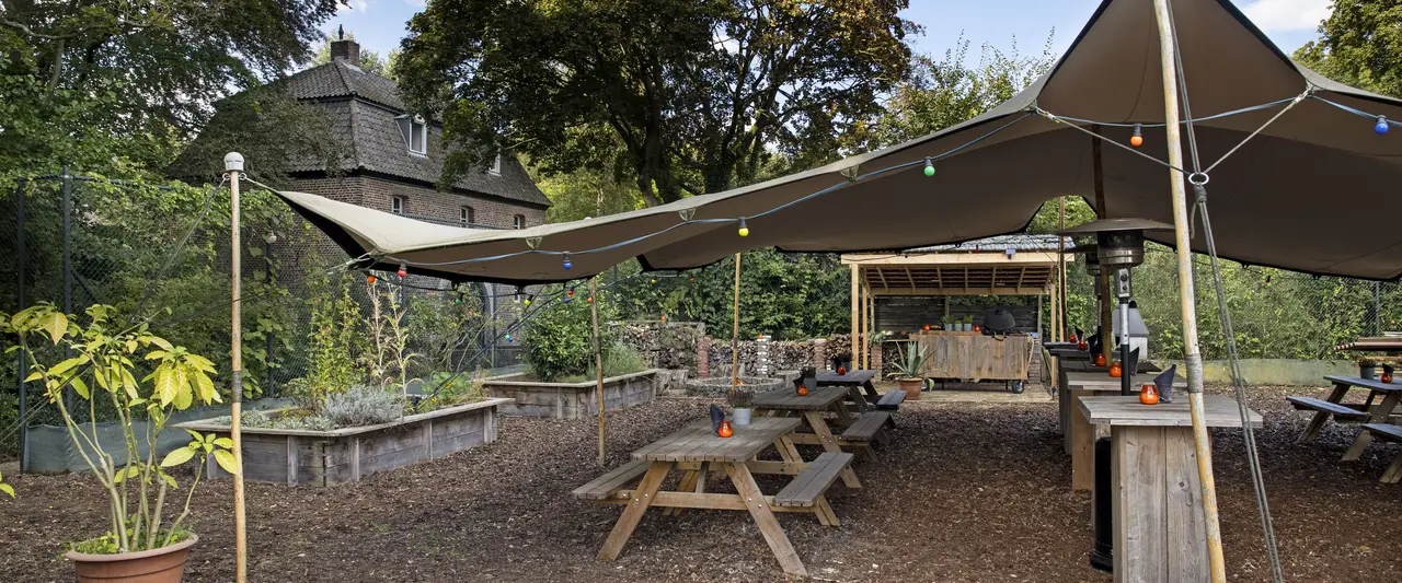 Zicht vanaf de tent in de kruidentuin met op de achtergrond Château Holtmühle