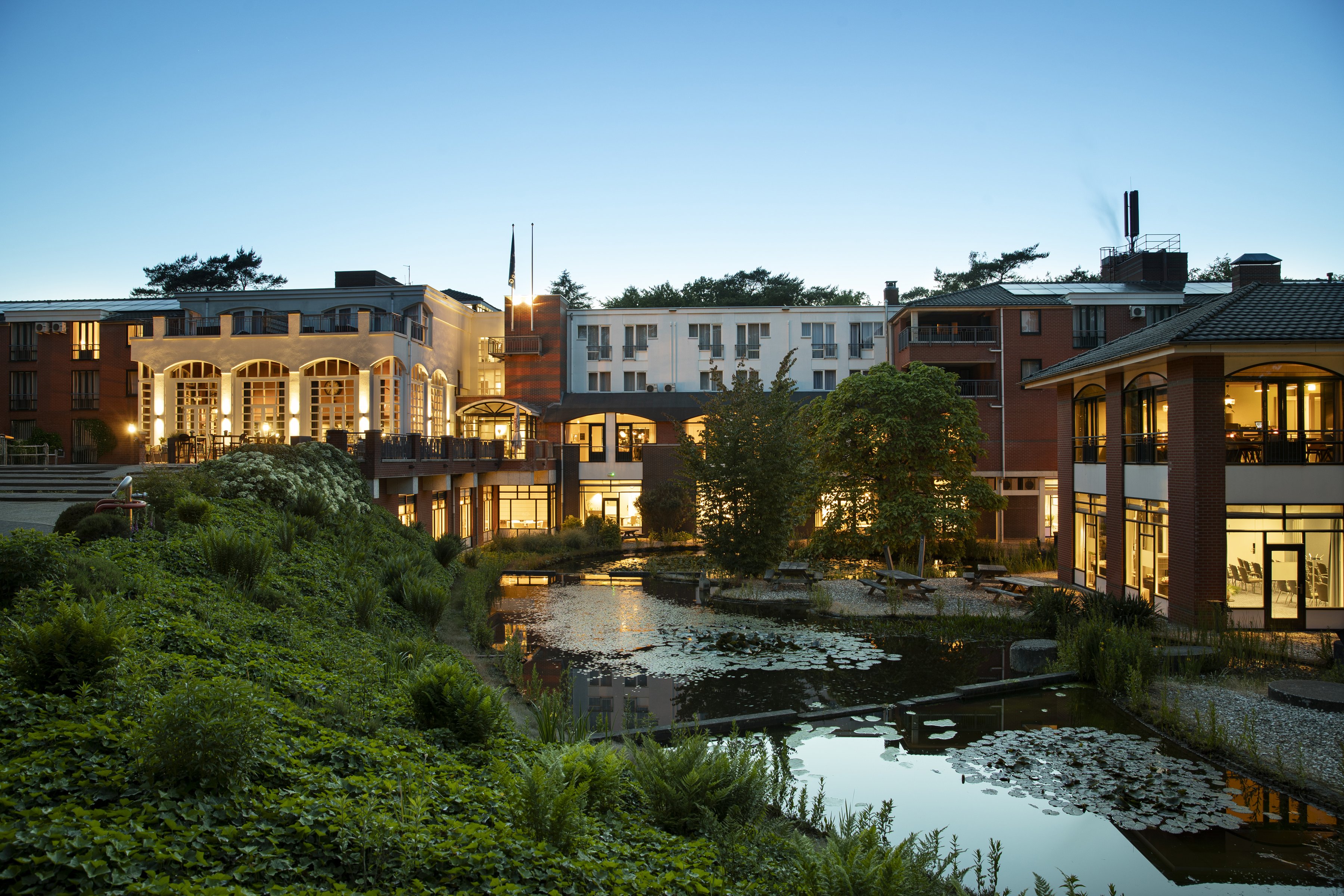 Hotel Residence Groot Heideborgh mit beleuchteter Fassade und Teich