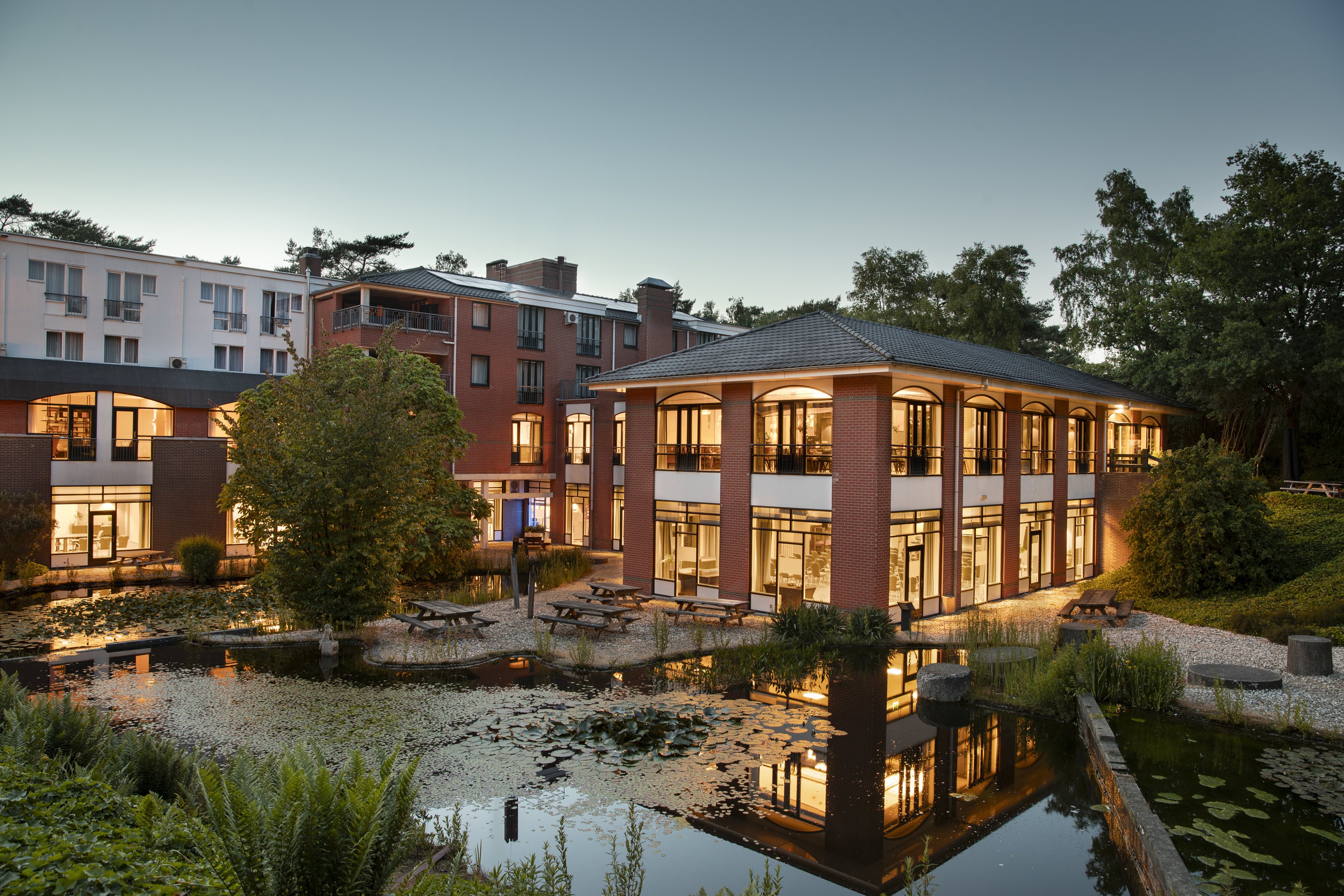 Hotel Residence Groot Heideborgh mit beleuchteter Fassade und Teich