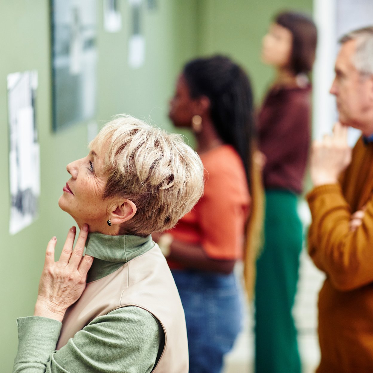 Een mevrouw die in een museum naar een museumstuk kijkt.