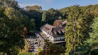 Luchtfoto van Hotel De Bovenste Molen, omringd door het groene bosgebied van Jammerdal.