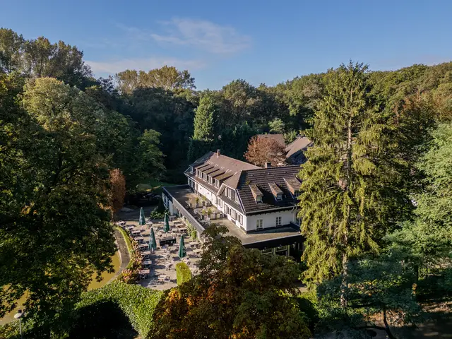 Luchtfoto van Hotel De Bovenste Molen, omringd door het groene bosgebied van Jammerdal.