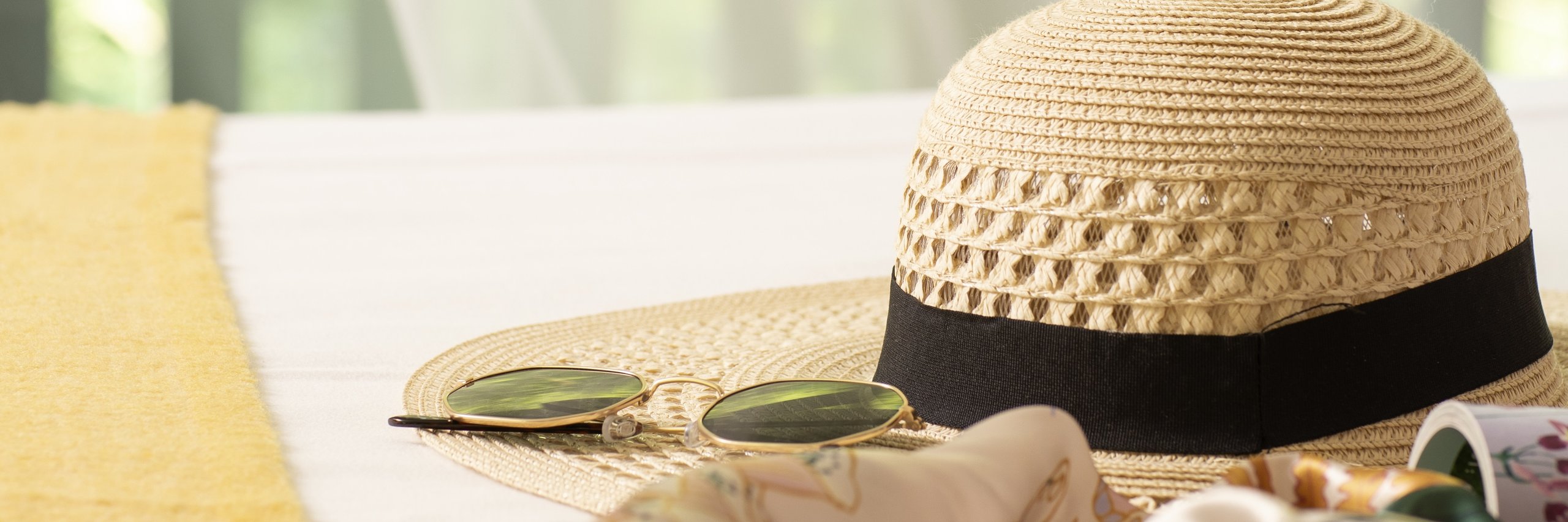 Eine Sonnenbrille und ein Hut beim Mittsommer-Arrangement in einem Hotelzimmer der Bilderberg Hotels.